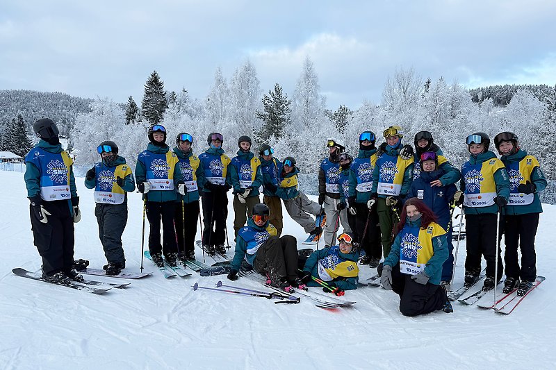 Gruppbild på Alla på snö-bild med backen i backgrunden