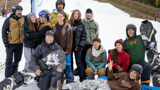 Grupp med snowboardledare i en backe